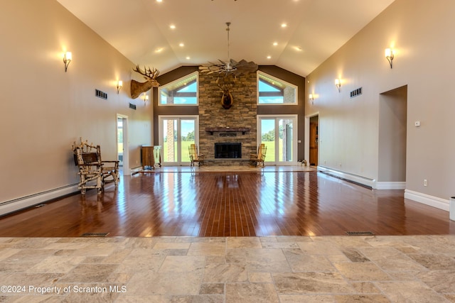 unfurnished living room with light wood-type flooring, a fireplace, high vaulted ceiling, and a baseboard heating unit