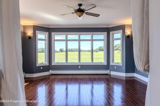 empty room featuring ornamental molding, baseboard heating, dark wood-type flooring, and ceiling fan