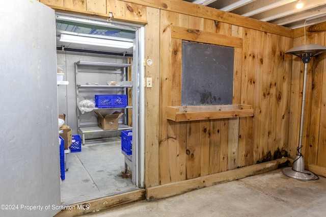 interior space with wood walls and concrete flooring