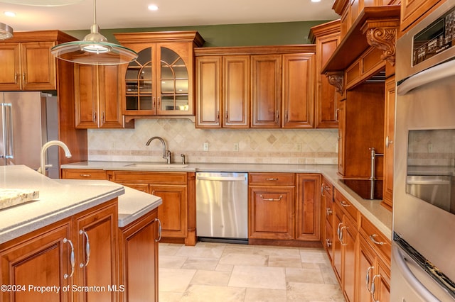 kitchen featuring sink, stainless steel appliances, hanging light fixtures, and tasteful backsplash