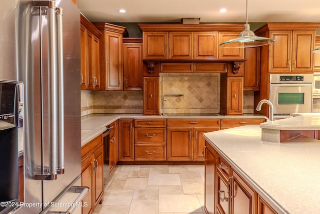 kitchen featuring appliances with stainless steel finishes, backsplash, hanging light fixtures, and sink