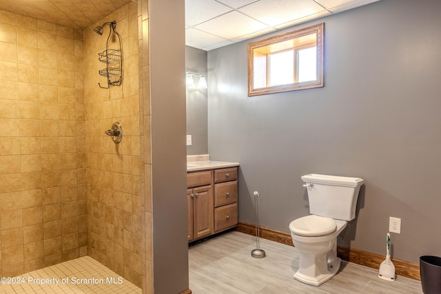 bathroom with hardwood / wood-style flooring, toilet, vanity, and tiled shower