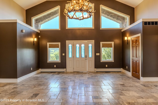 foyer entrance featuring a chandelier, a towering ceiling, and a baseboard radiator