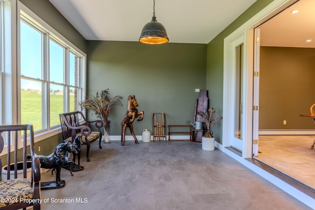 sunroom / solarium with a baseboard radiator and a healthy amount of sunlight