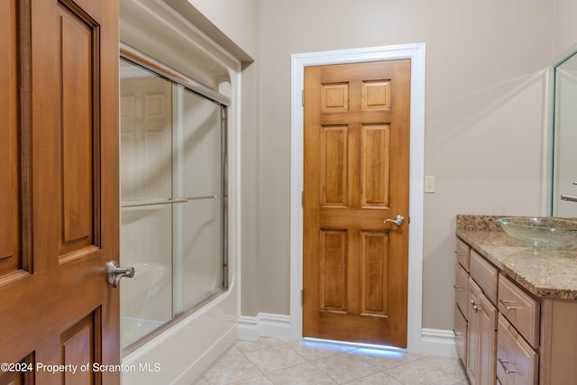 bathroom featuring tile patterned flooring, vanity, and combined bath / shower with glass door