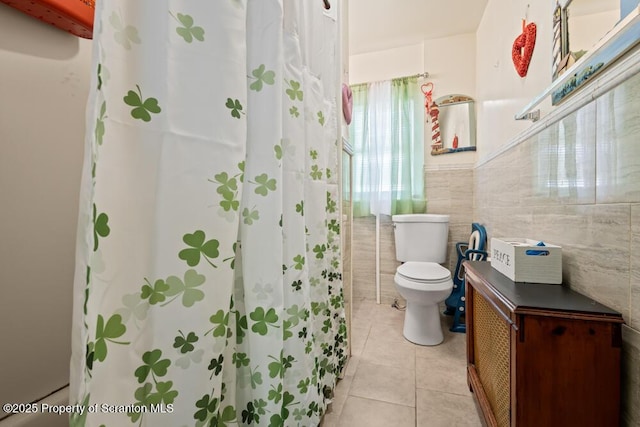 full bathroom featuring toilet, tile walls, and tile patterned flooring