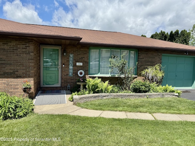 102 Bubernak Blvd, Old Forge, PA 18518 - view of exterior entry featuring brick siding, a garage, and a lawn