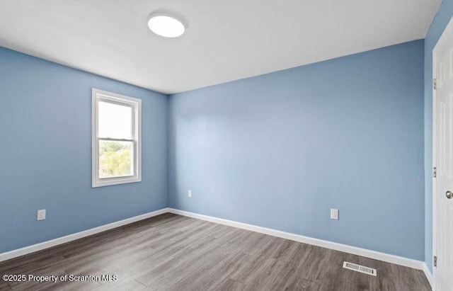 unfurnished room with hardwood / wood-style flooring