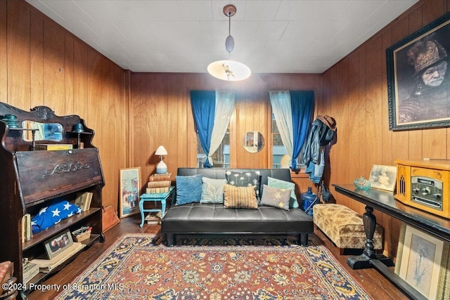 living area with dark hardwood / wood-style floors and wooden walls