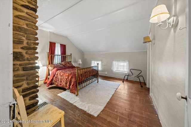 bedroom with vaulted ceiling and hardwood / wood-style flooring