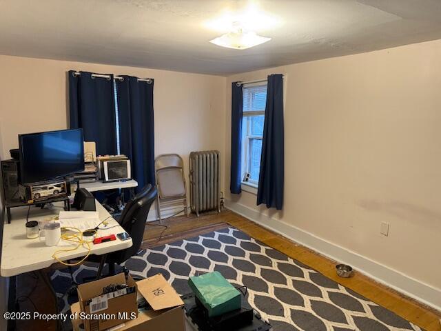 office area with radiator and dark wood-type flooring