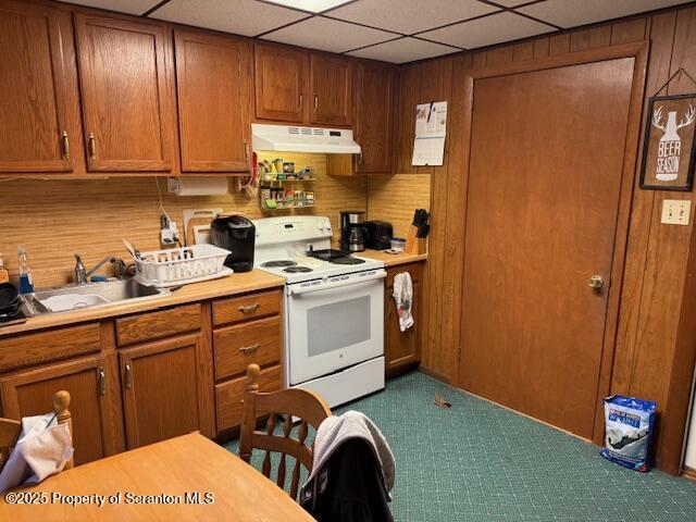 kitchen with a paneled ceiling, electric range, and sink