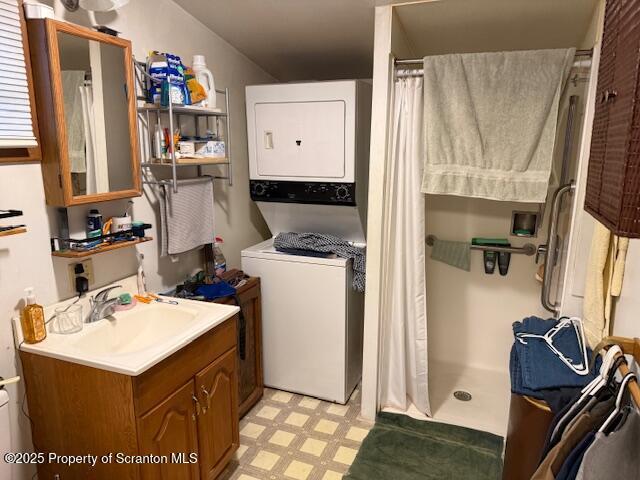 laundry room with stacked washer / dryer and sink