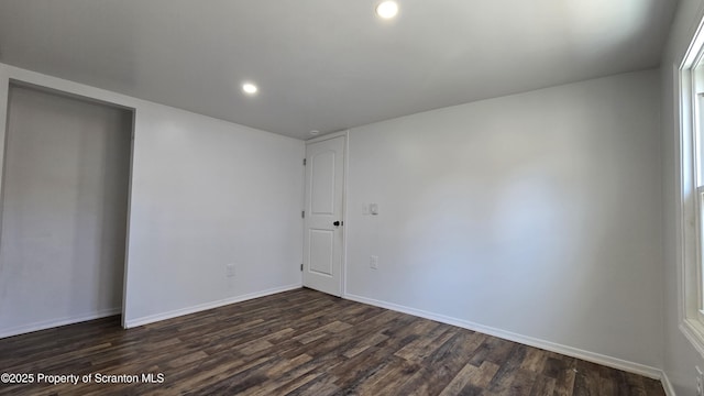 unfurnished room with recessed lighting, baseboards, and dark wood finished floors