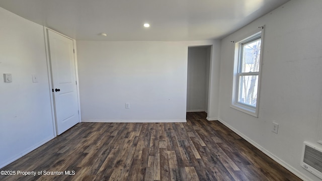 spare room featuring recessed lighting, baseboards, and dark wood-style floors