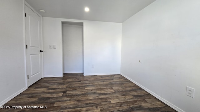 unfurnished bedroom featuring wood finished floors, baseboards, and a closet