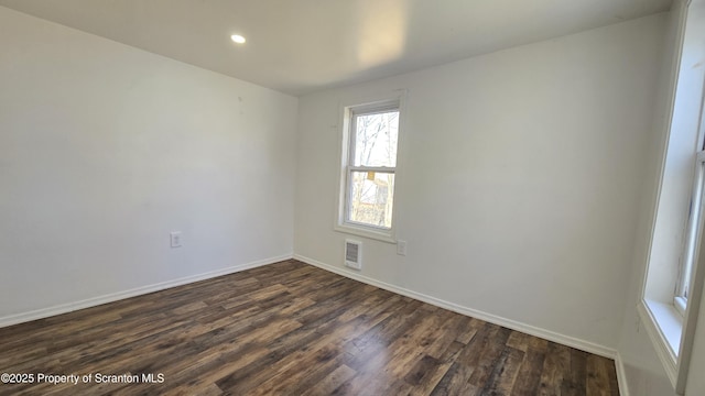 spare room featuring recessed lighting, visible vents, baseboards, and dark wood-style flooring