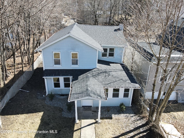 exterior space with fence and a shingled roof