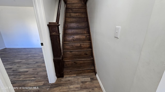 staircase with baseboards and wood finished floors