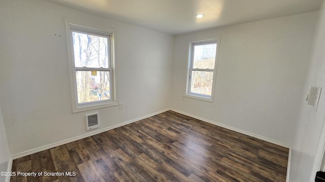 spare room featuring dark wood-style floors, visible vents, recessed lighting, and baseboards