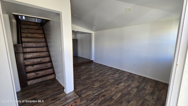 interior space with vaulted ceiling, wood finished floors, and baseboards