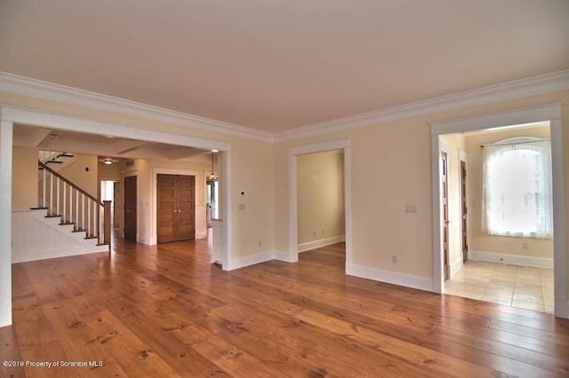 unfurnished living room with hardwood / wood-style flooring and crown molding