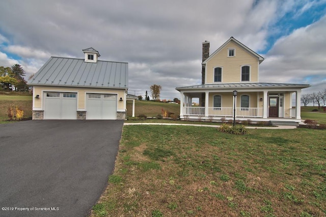 farmhouse with covered porch, a garage, and a front lawn