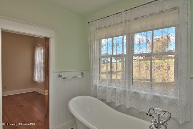 bathroom with hardwood / wood-style floors and a bath