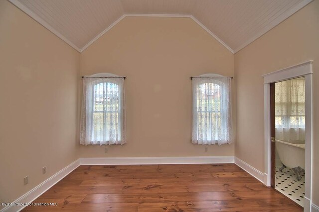 spare room with high vaulted ceiling, wood-type flooring, ornamental molding, and a wealth of natural light