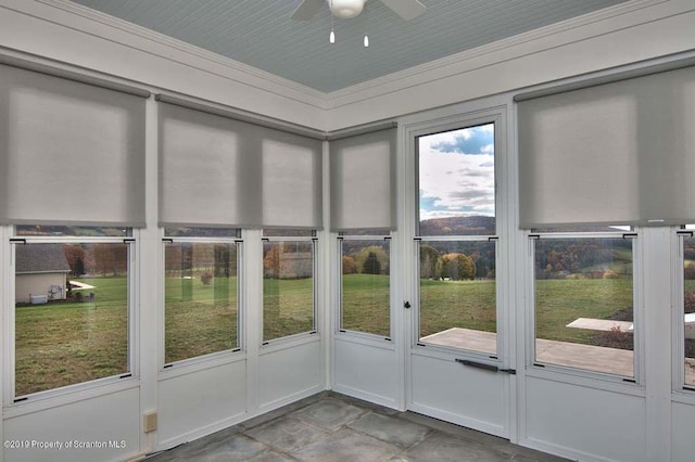 unfurnished sunroom with ceiling fan