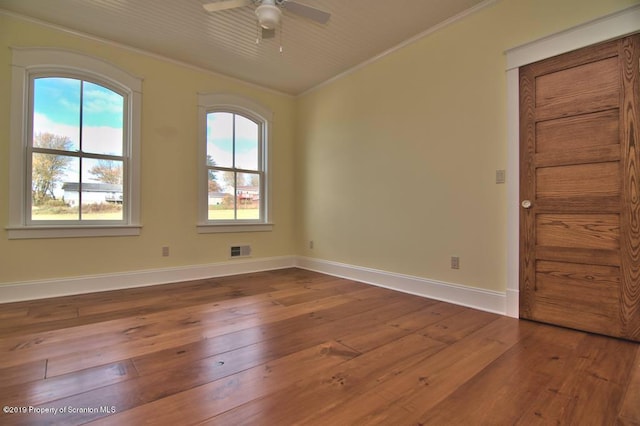 unfurnished room featuring plenty of natural light, ceiling fan, wood-type flooring, and ornamental molding