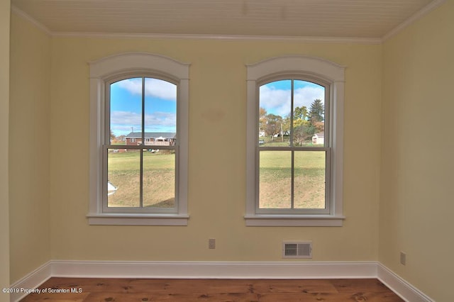 spare room featuring hardwood / wood-style flooring and ornamental molding