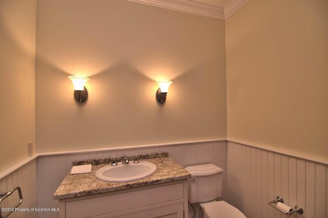 bathroom featuring vanity, toilet, and crown molding