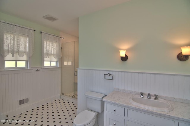 bathroom with tile patterned floors, toilet, vanity, and walk in shower