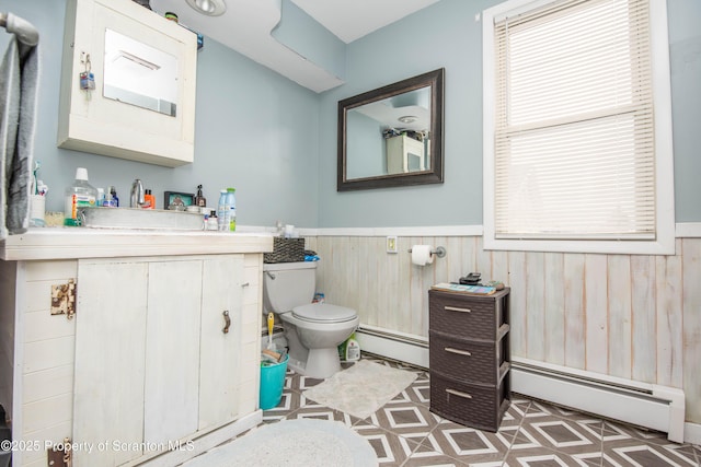 bathroom featuring vanity, a baseboard radiator, toilet, and wood walls