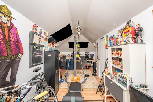 game room with rail lighting, vaulted ceiling, and hardwood / wood-style floors