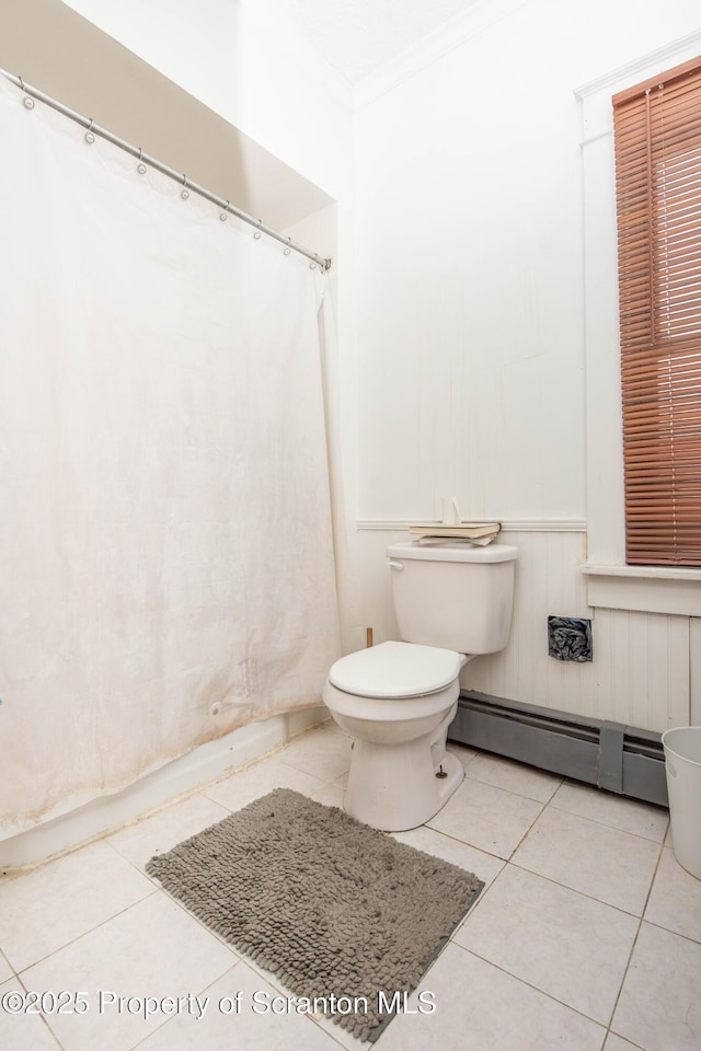 bathroom with tile patterned flooring, a baseboard heating unit, crown molding, and toilet