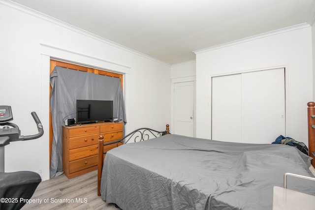 bedroom with a closet, ornamental molding, and light hardwood / wood-style flooring