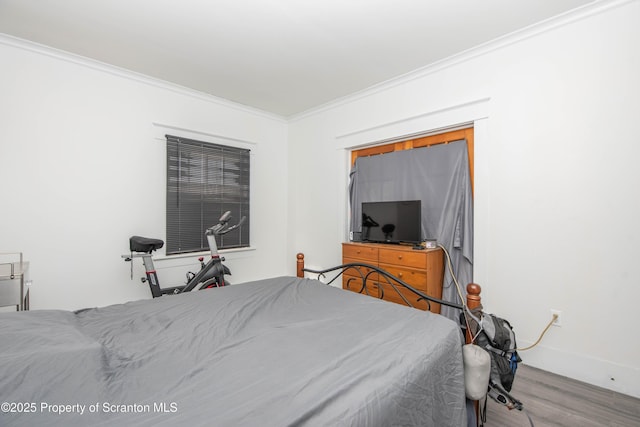 bedroom with wood-type flooring and ornamental molding