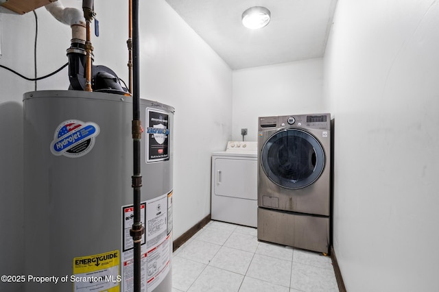 clothes washing area with light tile patterned floors, laundry area, baseboards, water heater, and independent washer and dryer