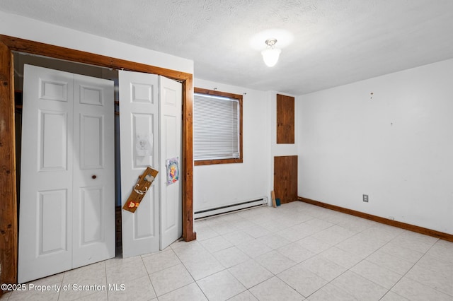 interior space featuring a baseboard radiator, a closet, light tile patterned flooring, a textured ceiling, and baseboards