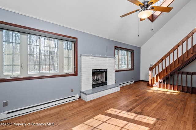 unfurnished living room featuring stairs, a baseboard heating unit, a fireplace, and wood finished floors