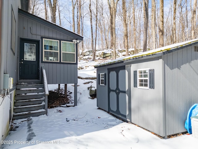 snow covered structure featuring entry steps