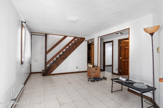 below grade area featuring baseboards, stairway, baseboard heating, and a textured ceiling