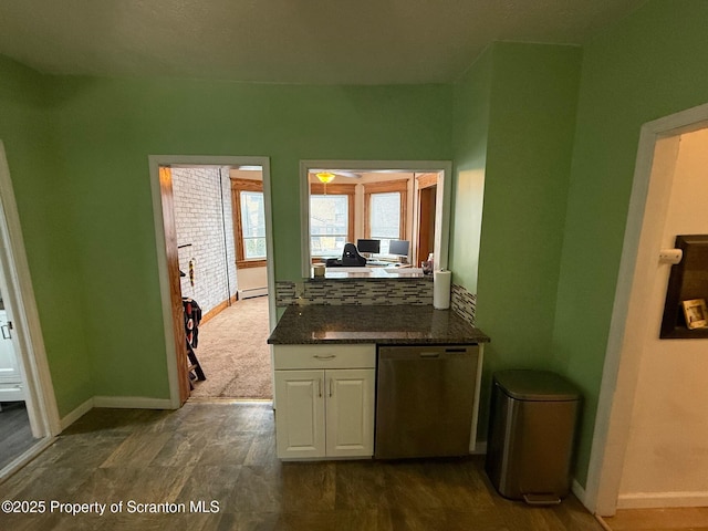 interior space with white cabinetry, a baseboard heating unit, dark wood-type flooring, and stainless steel dishwasher