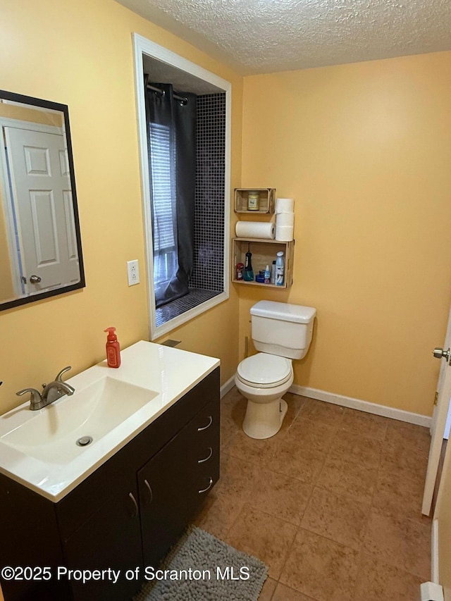 bathroom featuring vanity, toilet, and a textured ceiling