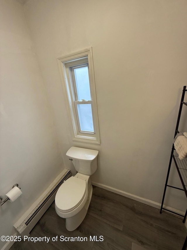 bathroom with a baseboard radiator, toilet, and wood-type flooring