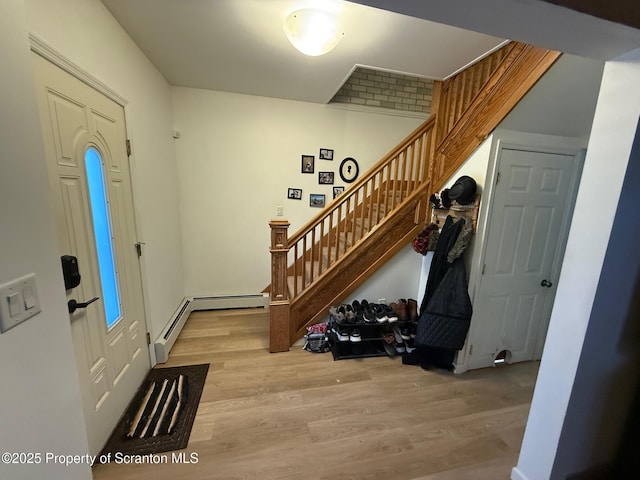 foyer entrance with a baseboard radiator and light wood-type flooring