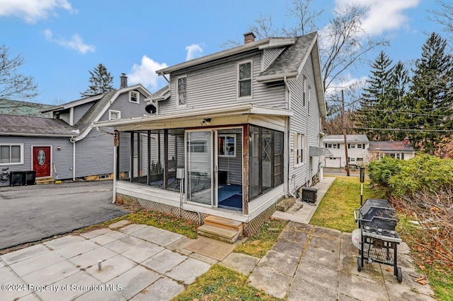 rear view of property with a sunroom