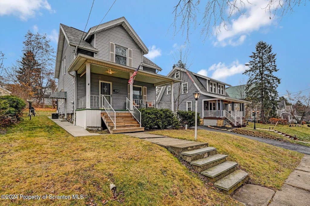 view of front of home featuring covered porch and a front lawn